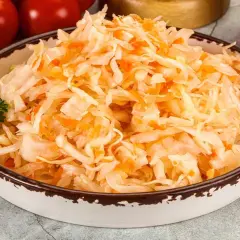 Miseczka z surówką z kiszonej kapusty i marchewki, idealna do przygotowania z miodem.