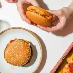 Jak dobrać mięso na domowe burgery? Zawartość tłuszczu a soczystość. Na stole burger, pizza i napój.