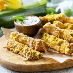 Chrupiące frytki z cukinii w panierce panko, podane z sosem. Idealna przekąska, która udowadnia, że frytki z cukinii można zrobić w panierce panko.