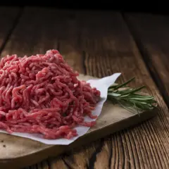 Świeże mielone mięso wołowe na desce. Przyczyny szarzenia mięsa wołowego w środku opakowania mogą być związane z jego składem i przechowywaniem.