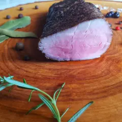 Idealnie różowe polędwiczki wieprzowe, idealne do przygotowania metodą sous-vide w domu. Zioła i pieprz dopełniają danie.