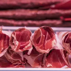 Roladki szynki, ukazujące różnicę między szynką parmeńską a serrano w procesie dojrzewania.