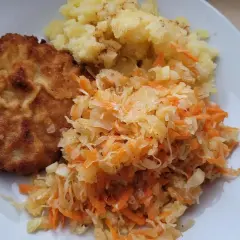 Złocisty kotlet schabowy z ziemniakami i surówką z kapusty i marchewki – idealne połączenie, co pasuje do schabowego.