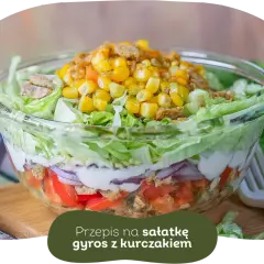 Warstwowa sałatka gyros z kurczakiem, pomidorami, cebulą i kukurydzą. Idealna, gdy zastanawiasz się, czy sałatkę gyros można zrobić dzień wcześniej.