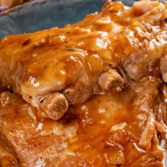 Soczyste żeberka pieczone w aromatycznym sosie, podane w niebieskiej misie. Idealne na obiad!