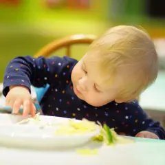 Małe dziecko próbuje kolorowej surówki tęczowej. Przepis na nią i lista składników to świetny sposób na zachęcenie niejadka do jedzenia.