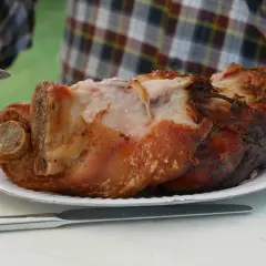 Soczysta golonka na talerzu, gotowa do krojenia. Różnica między golonką przednią a tylną w kulinariach jest widoczna w strukturze mięsa.