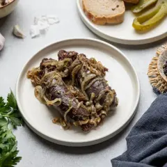Kaszanka na patelni z cebulką, podana z pieczywem i ogórkiem. Idealny sposób, jak zrobić kaszankę na patelni.