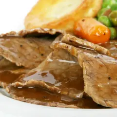 Soczysta, pieczona wołowina w sosie, podana z ziemniakami i warzywami. Idealny przykład, jak upiec wołowinę w kawałku.