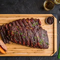 Pyszne, glazurowane żeberka na desce z batatami i sosem BBQ. Idealne co do żeberek na obiad!