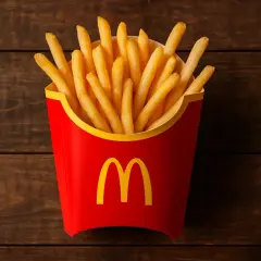 Czerwone pudełko z frytkami McDonald's na drewnianym tle.