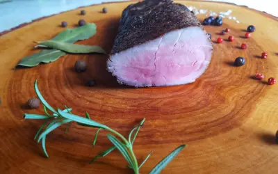 Idealnie różowe polędwiczki wieprzowe, idealne do przygotowania metodą sous-vide w domu. Zioła i pieprz dopełniają danie.