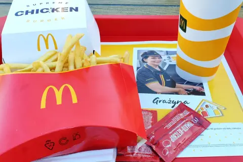 Na tacy McDonald's znajdują się duże frytki, burger supreme chicken, napój i ketchup.