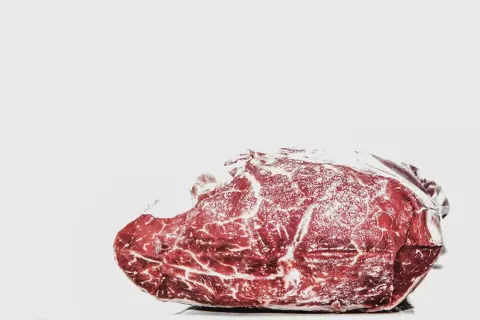 Surowe mięso z widocznymi żyłkami tłuszczu. Mrożenie mięsa dwa razy jest niebezpieczne, bo pogarsza jego jakość i może sprzyjać rozwojowi bakterii.