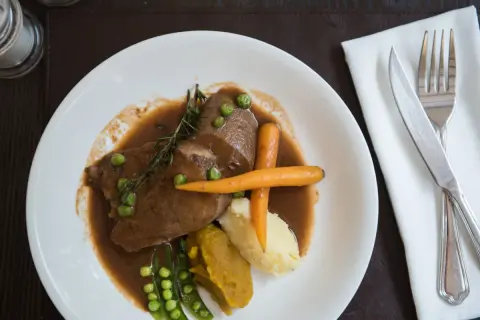 Jak przygotować ozory wieprzowe: delikatne plastry w sosie z puree, marchewką i groszkiem.