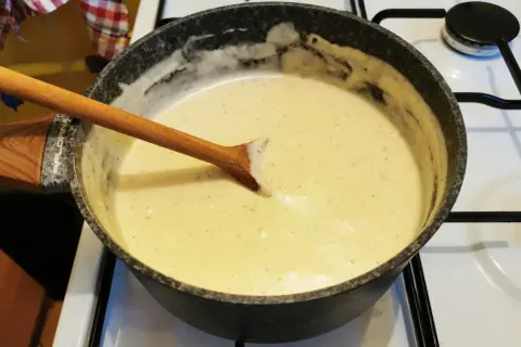 Kremowy sos na patelni, z drewnianą łyżką. Różnica między sosem beszamelowym a velouté w bazie i smaku jest subtelna, ale wyczuwalna.