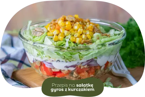 Warstwowa sałatka gyros z kurczakiem, pomidorami, cebulą i kukurydzą. Idealna, gdy zastanawiasz się, czy sałatkę gyros można zrobić dzień wcześniej.