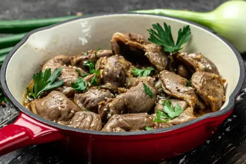 Gotowe do podania żołądki drobiowe w sosie, posypane sezamem i natką pietruszki. Dowiedz się, jak czyścić żołądki drobiowe, by były pyszne.