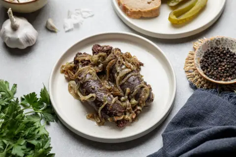 Kaszanka na patelni z cebulką, podana z pieczywem i ogórkiem. Idealny sposób, jak zrobić kaszankę na patelni.