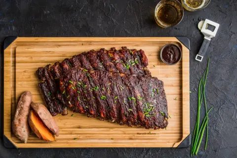 Pyszne, glazurowane żeberka na desce z batatami i sosem BBQ. Idealne co do żeberek na obiad!