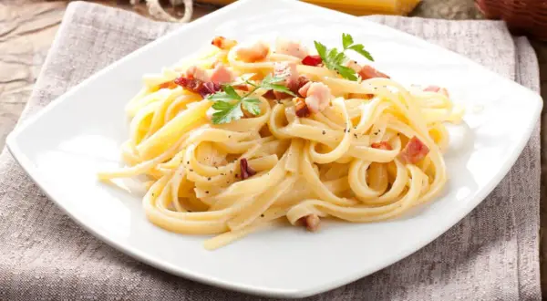 Prawdziwa carbonara bez śmietany, zgodnie z włoską tradycją. Makaron tagliatelle z guanciale, jajkami i parmezanem.