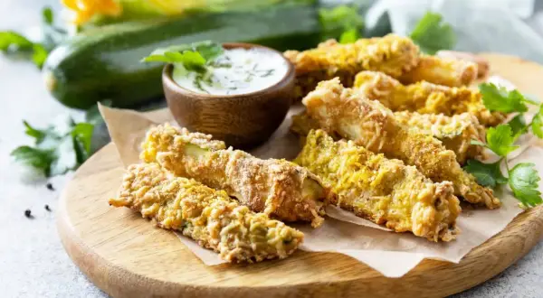Chrupiące frytki z cukinii w panierce panko, podane z sosem. Idealna przekąska, która udowadnia, że frytki z cukinii można zrobić w panierce panko.