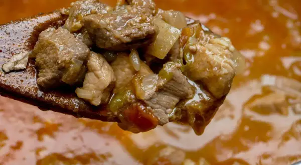 Kawałki mięsa na drewnianej łyżce, gotowe do gulaszu. Czy marynować mięso na gulasz? Ten wygląda apetycznie!