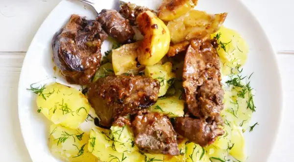 Smażona wątróbka drobiowa z jabłkami i ziemniakami, posypana koperkiem. Idealny sposób, jak przygotować wątróbkę drobiową do smażenia.