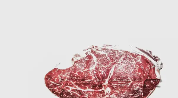 Surowe mięso z widocznymi żyłkami tłuszczu. Mrożenie mięsa dwa razy jest niebezpieczne, bo pogarsza jego jakość i może sprzyjać rozwojowi bakterii.