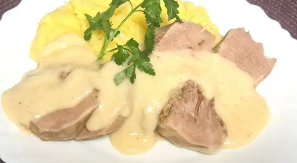 Jak zrobić ozorki w sosie chrzanowym: delikatne ozorki w kremowym sosie z chrzanem, podane z purée ziemniaczanym i natką pietruszki.