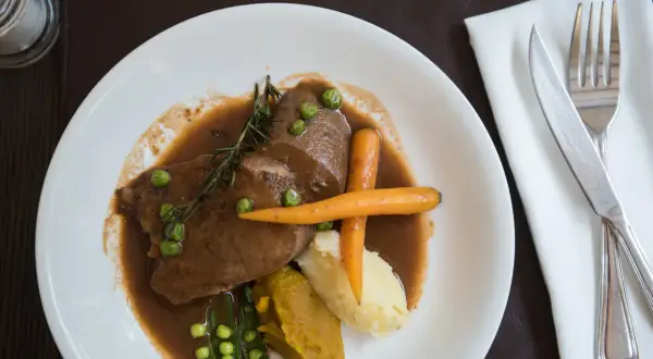 Jak przygotować ozory wieprzowe: delikatne plastry w sosie z puree, marchewką i groszkiem.