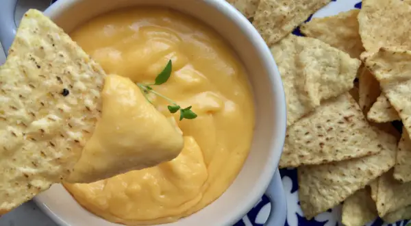 Jak przygotować sos serowy do frytek typu cheddar dip? Gęsty, kremowy sos serowy z nachosami, idealny do maczania.