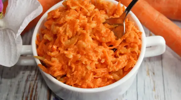 Tarta marchewka z jabłkiem i chrzanem w białej miseczce. Różnica smaków między słodką a ostrą surówką.