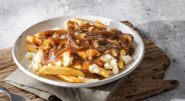Pyszne frytki poutine z sosem pieczeniowym i serem. Idealne danie, gdy chcesz wiedzieć, jak zrobić frytki poutine.