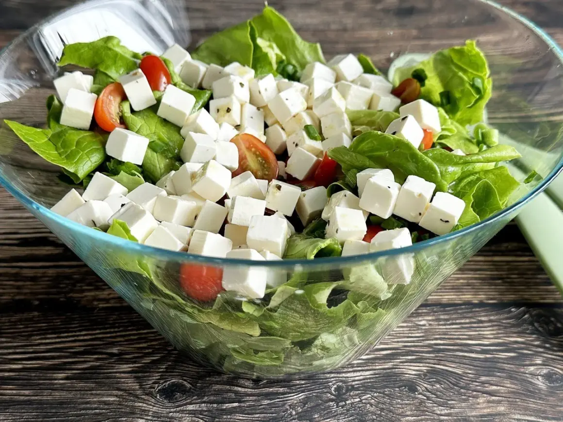 Sałatka z kostkami tofu, która smakuje jak feta. Zielona sałata, pomidorki koktajlowe i tofu w szklanej misie.