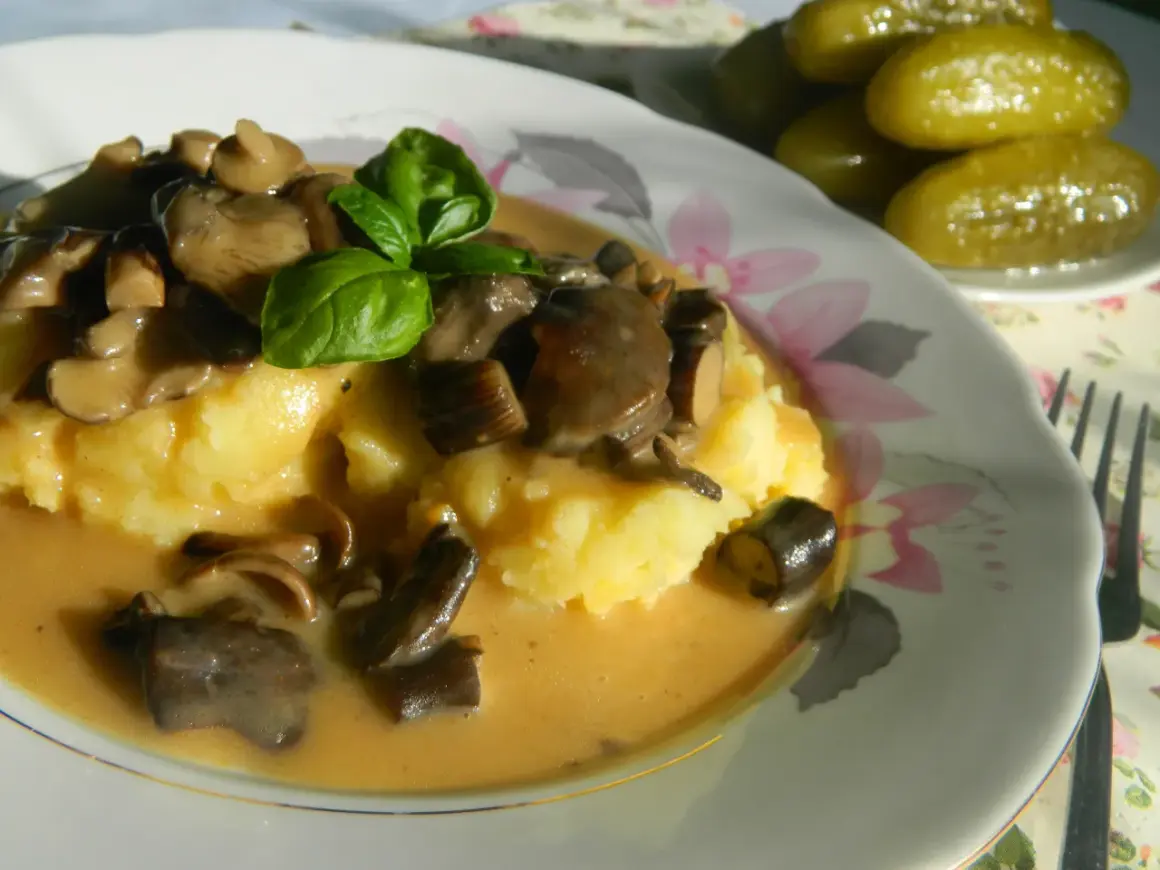 Pyszny ziemniaczany purée z sosem z opieniek, udekorowany bazylią. Idealny przepis, jak zrobić sos z opieniek.