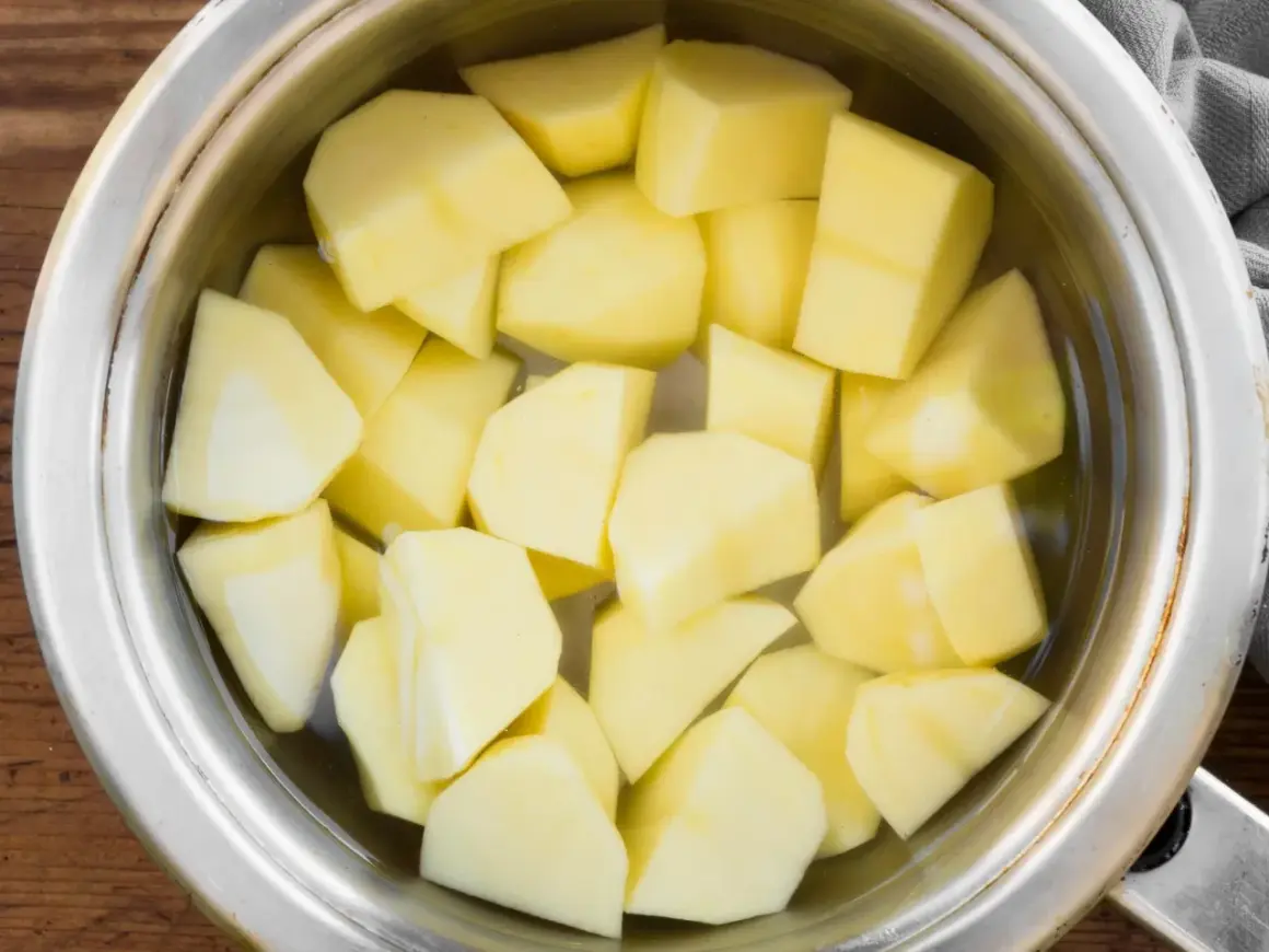 Pokrojone ziemniaki w garnku z wodą, gotowe do przygotowania idealnej sałatki. Czas gotowania ziemniaków na sałatkę jest kluczowy.