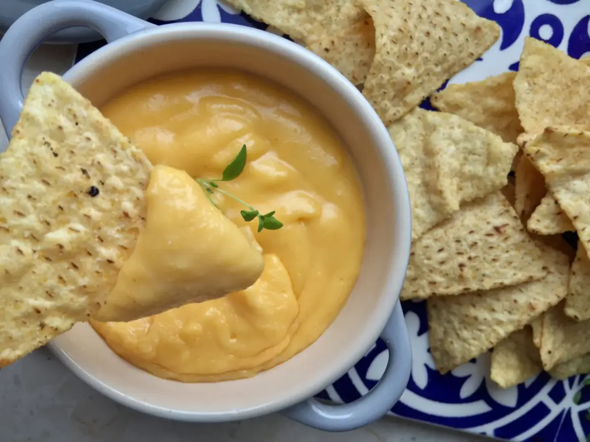 Jak przygotować sos serowy do frytek typu cheddar dip? Gęsty, kremowy sos serowy z nachosami, idealny do maczania.
