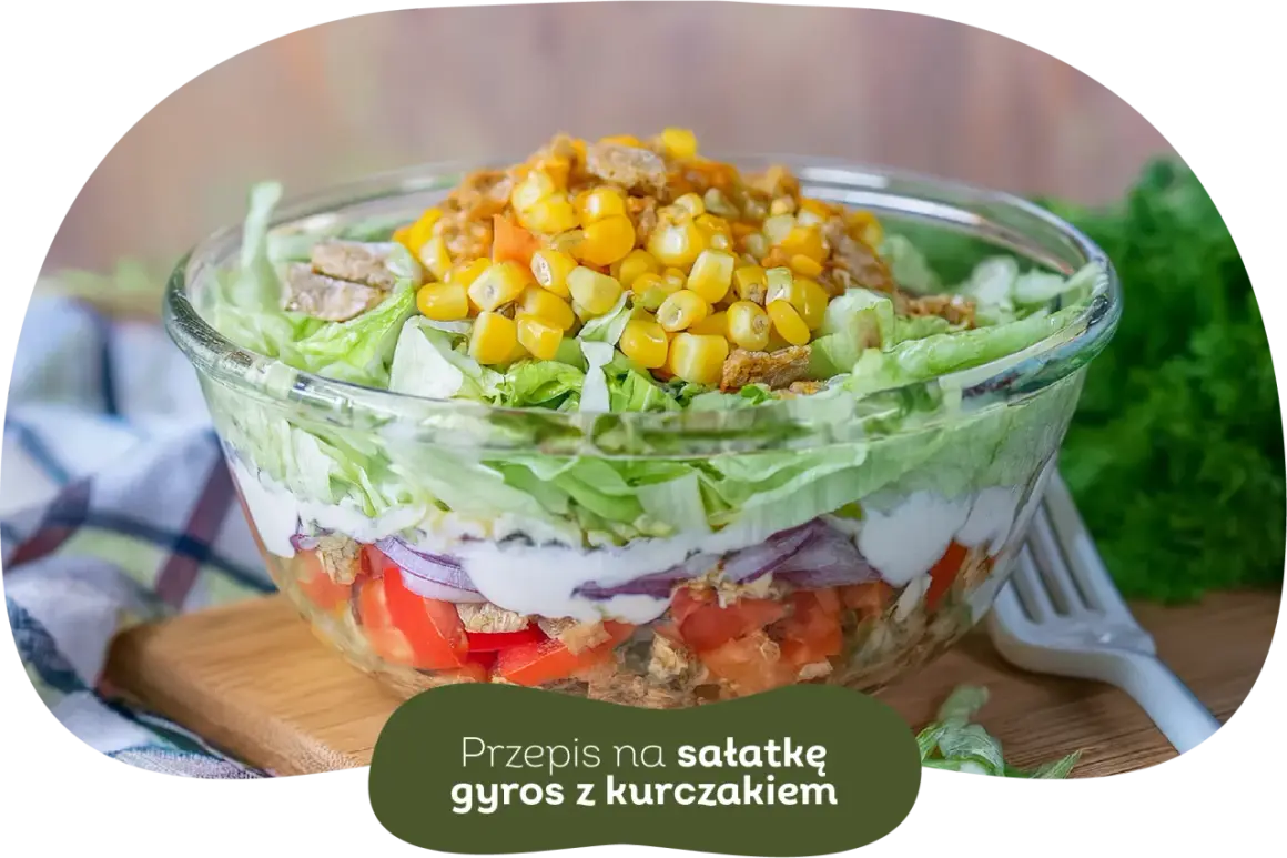 Warstwowa sałatka gyros z kurczakiem, pomidorami, cebulą i kukurydzą. Idealna, gdy zastanawiasz się, czy sałatkę gyros można zrobić dzień wcześniej.