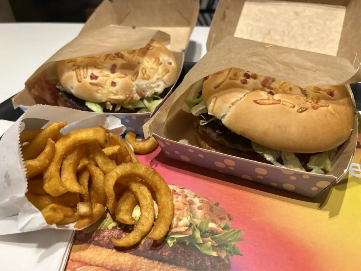 Dwa burgery i porcja zakręconych frytek. Zastanawiasz się, ile kosztują frytki zakręcone w maku? Smacznego!