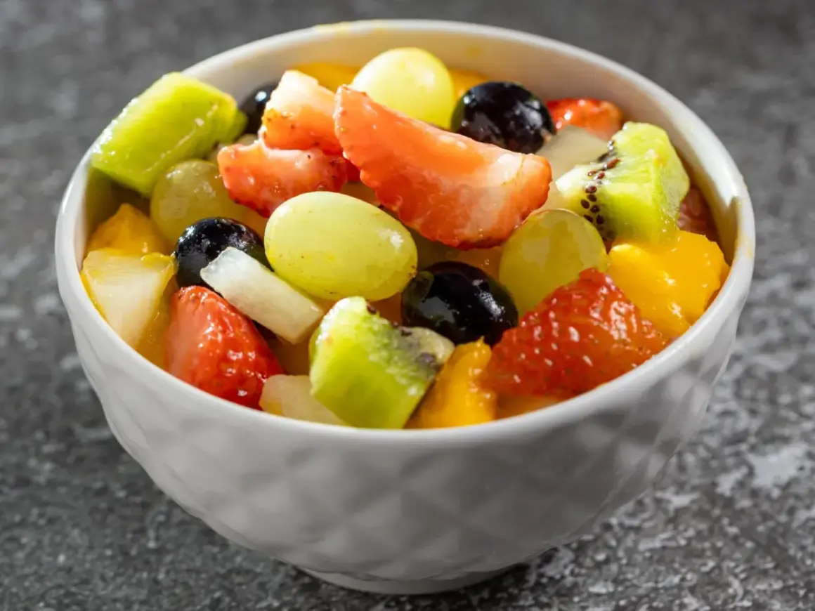 Kolorowa sałatka owocowa z truskawkami, kiwi, winogronami i mango. Idealna na lato, dowiedz się jak przygotować sałatkę owocową która nie ciemnieje przez kilka godzin.