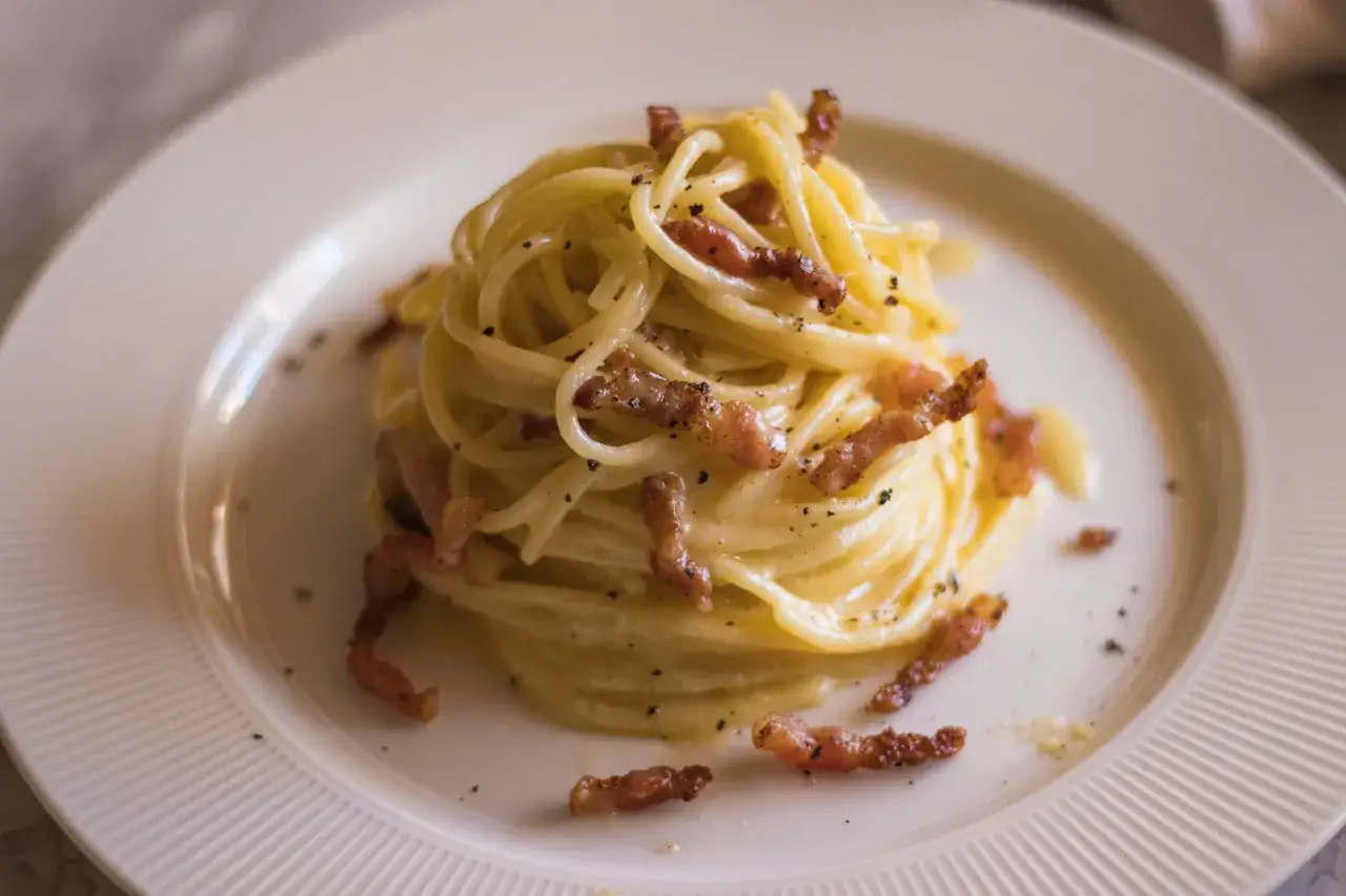 Pyszne spaghetti carbonara, przygotowane według oryginalnego przepisu, z chrupiącym guanciale i kremowym sosem.