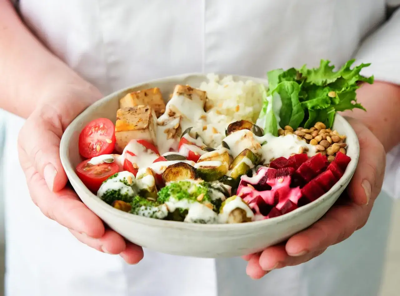 Miseczka pełna kolorowych warzyw i kostek tofu, które dzięki odpowiedniemu przygotowaniu smakują jak ser feta.