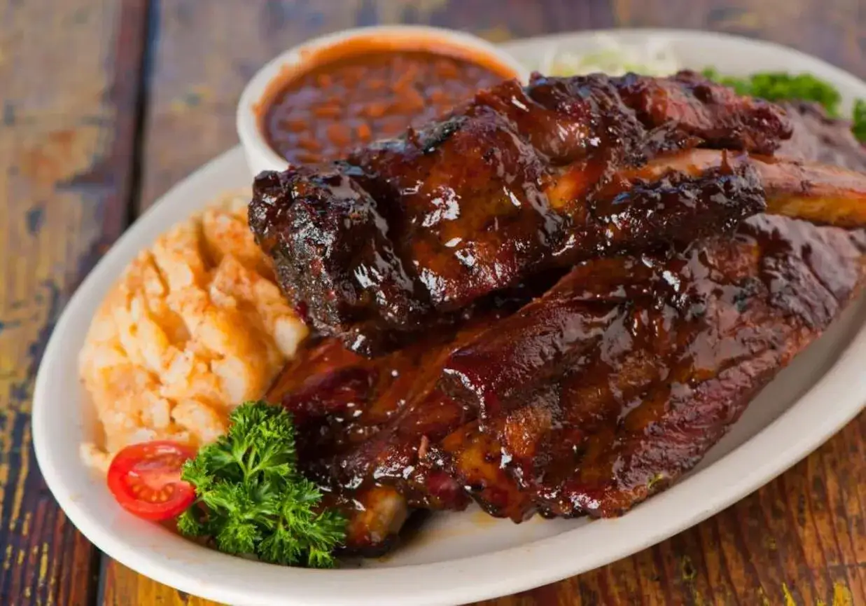 Soczyste żeberka w sosie BBQ, podane z puree ziemniaczanym i fasolką. Dowiedz się, jak usunąć błony z żeberek przed pieczeniem w miodzie, by były idealne.