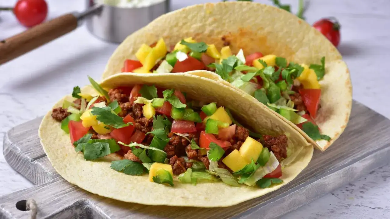 Dwa pyszne tacos z mięsem mielonym, polane świeżymi warzywami i mango. Idealne na szybki obiad!