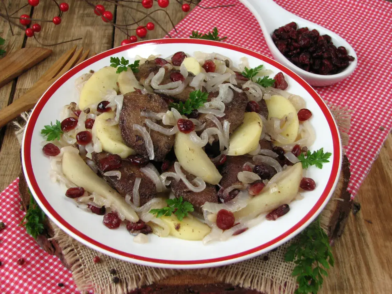 Wątróbka z jabłkami i żurawiną, idealnie pasuje do wątróbki. Danie ozdobione natką pietruszki.
