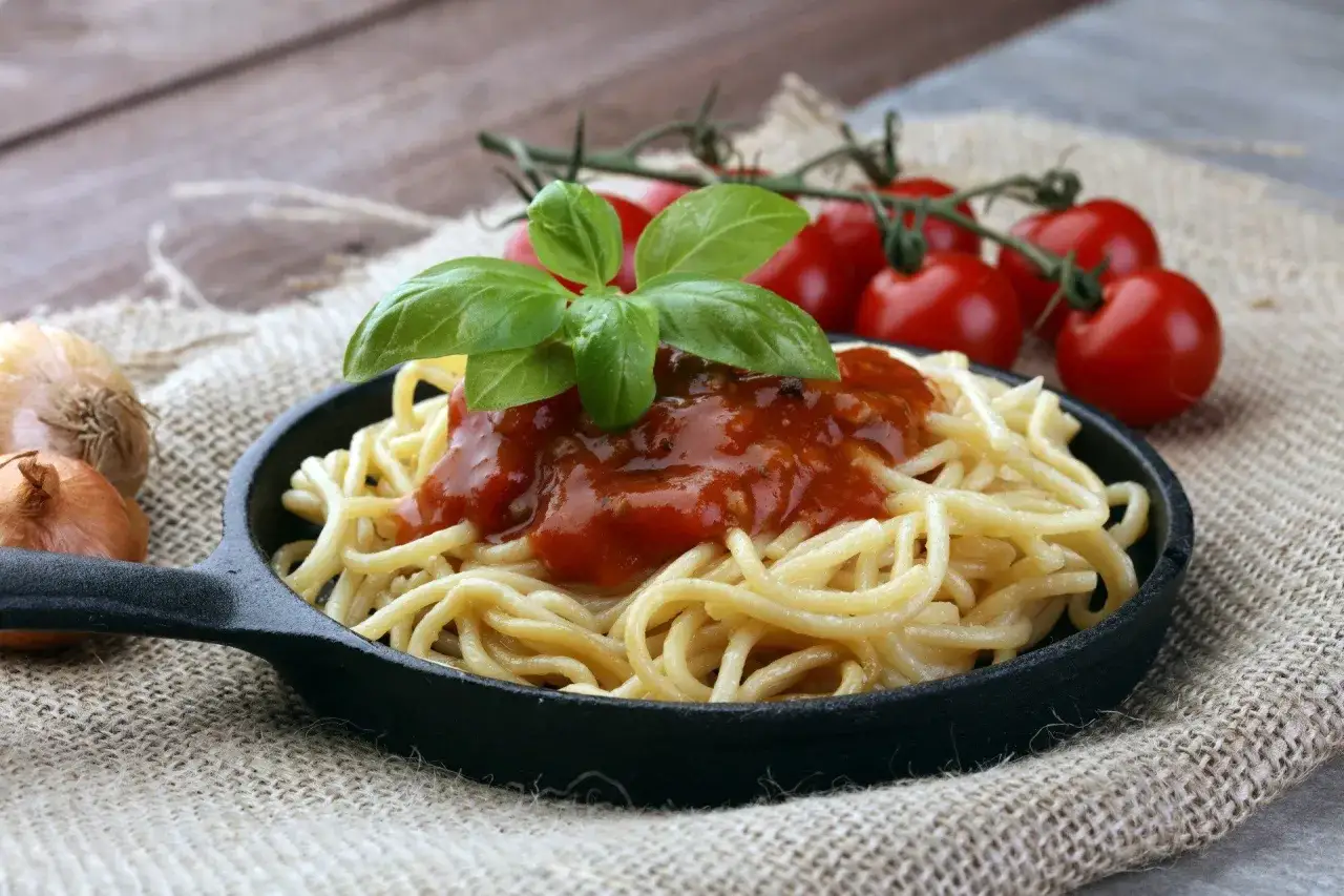 Jak dobrać sos do makaronu spaghetti a penne? Zasady przywierania sosu do makaronu, z pomidorami i bazylią.