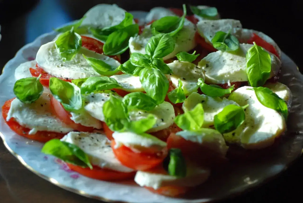 Sałatka caprese z pomidorów i mozzarelli. Przyczyny podchodzenia wodą mogą być różne, np. zbyt dojrzałe pomidory lub niewłaściwe przechowywanie.