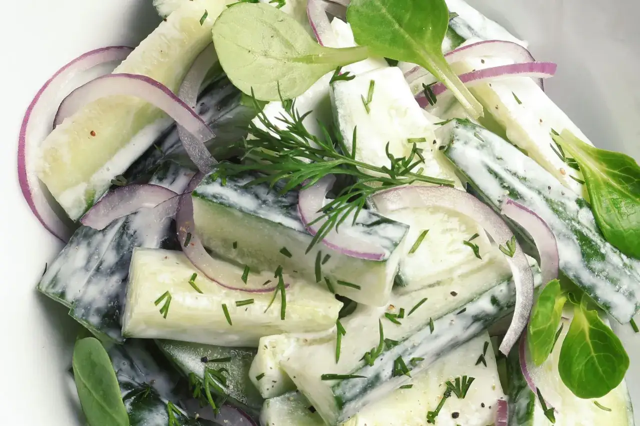 Kremowa mizeria z ogórków, cebuli i koperku. Różnica między surówką coleslaw a klasyczną mizerią z octem jest widoczna w sosie.