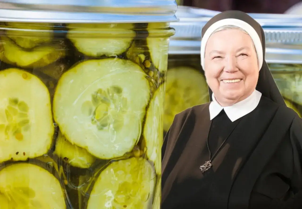 Skutki solenia ogórków do sałatki zbyt wcześnie: puszczają wodę, bo sól wyciąga z nich wilgoć. Siostra zakonna uśmiecha się obok słoików z ogórkami.